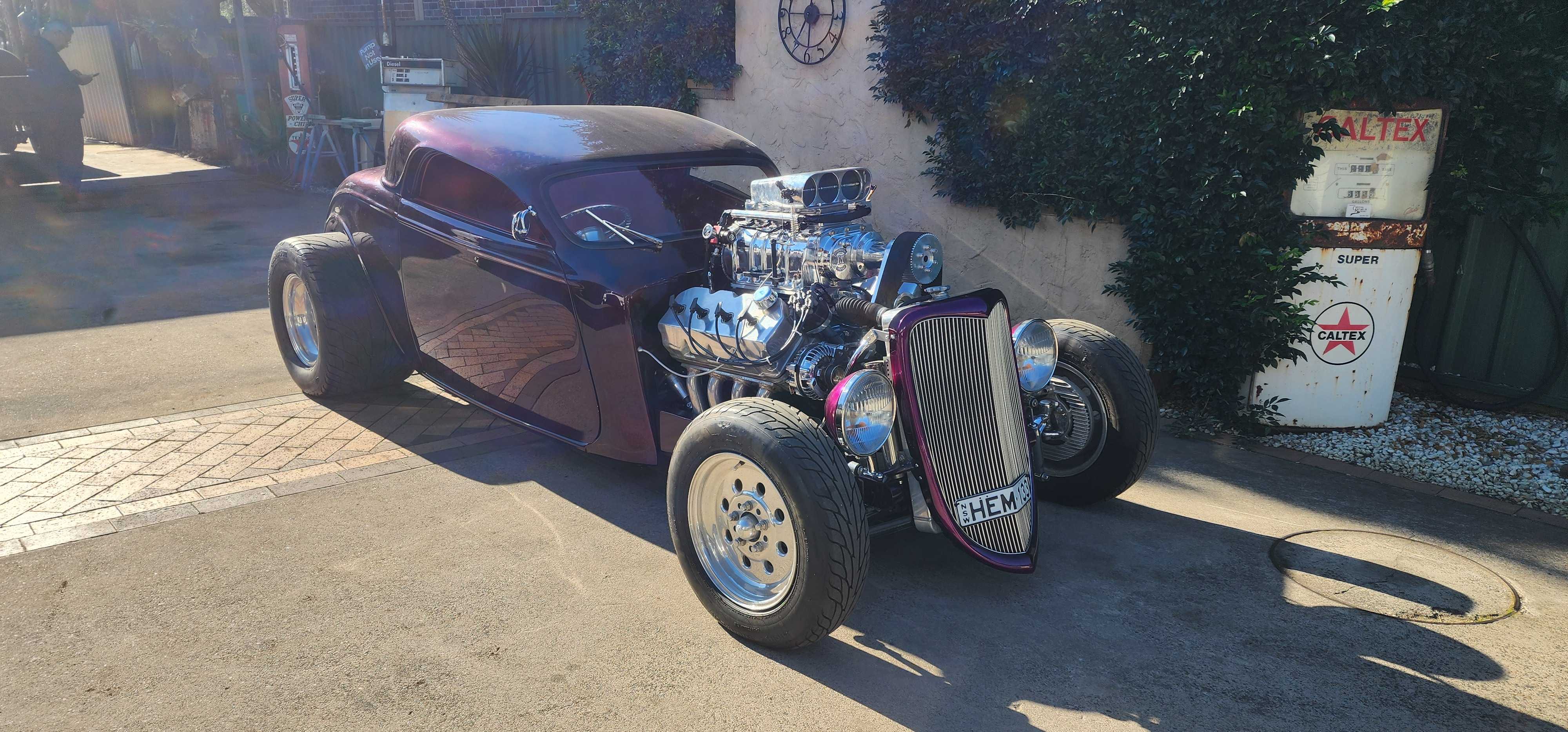 Deep purple hot rod coupe with a polished blown Hemi and injector hat, parked in the sun