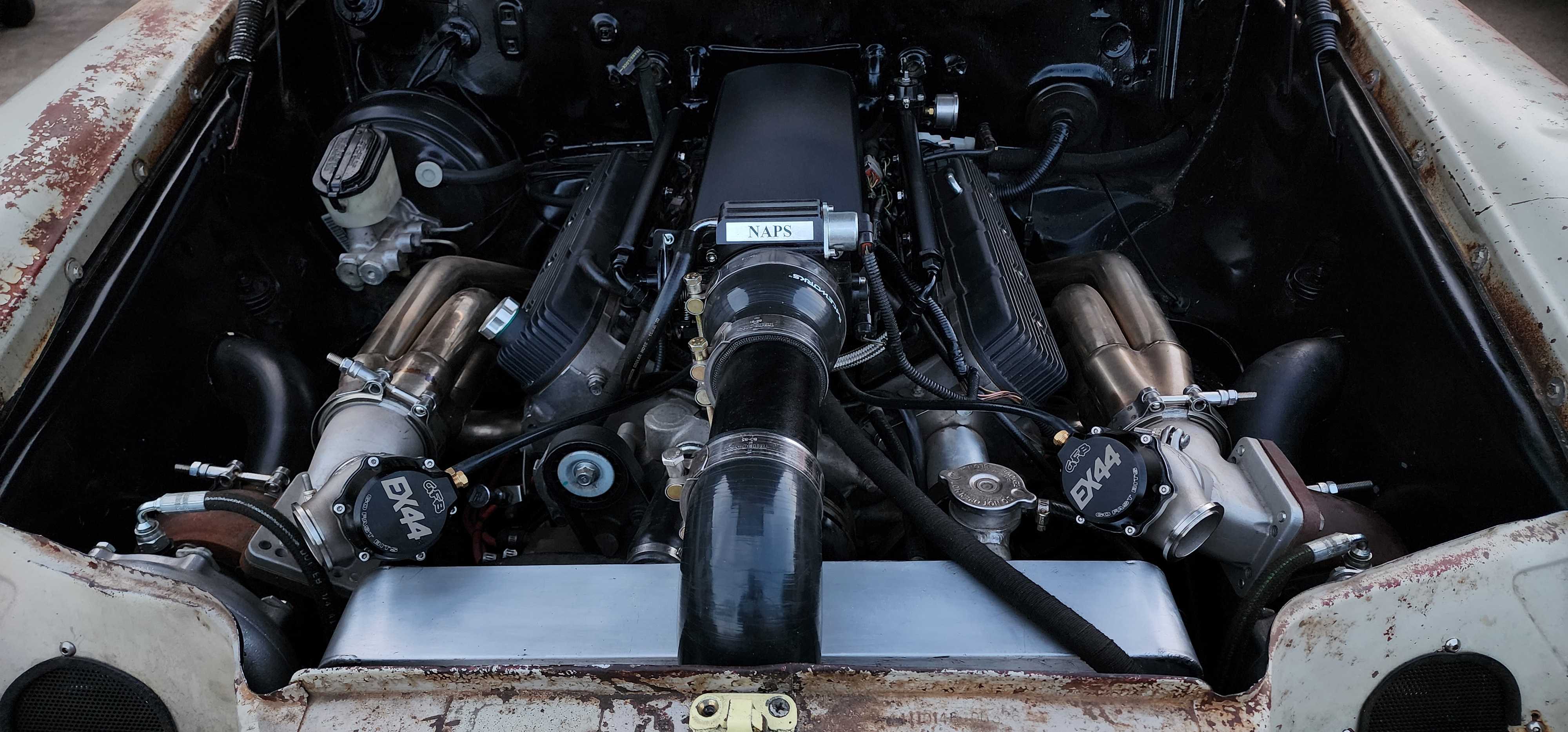 Twin turbo engine bay with custom manifolds, wastegates and charge piping fitted into a bare shell